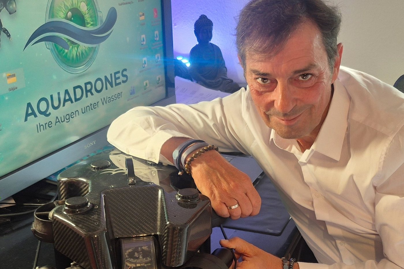 Michael Badura am Schreibtisch mit ROV und Aquadrones-Logo auf dem Monitor