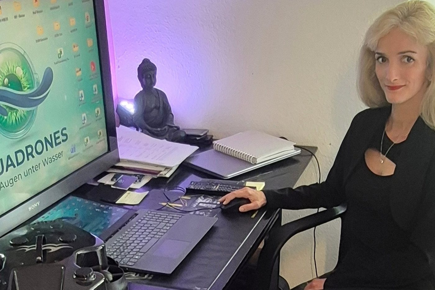 Hana Sedova im Büro, im Hintergrund das Aquadrones-Logo auf dem Monitor
