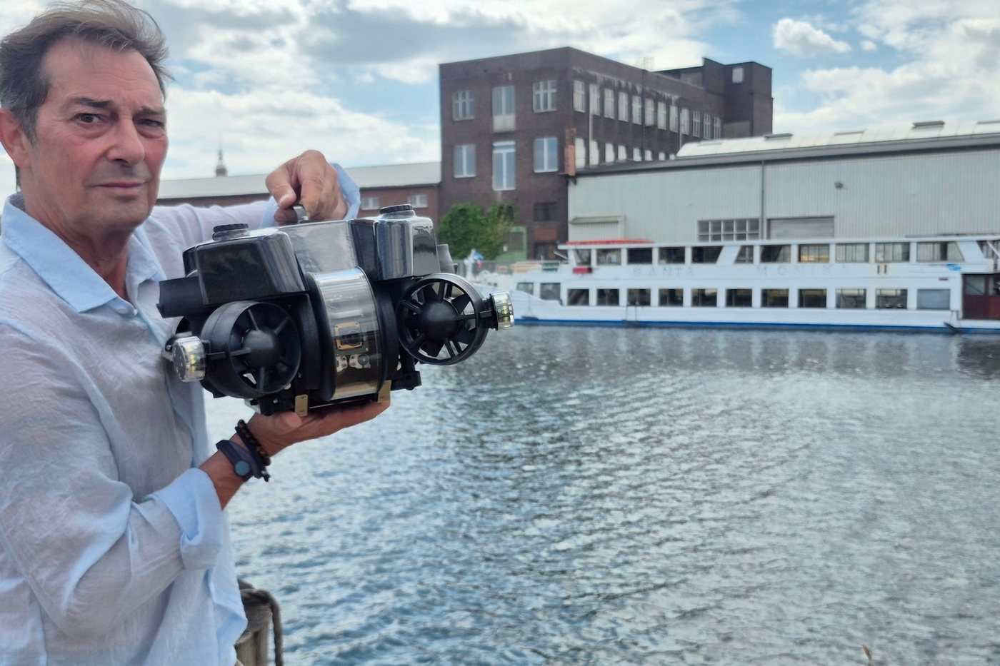 Michael Badura am Hafenbecken mit ROV, im Hintergrund ein Schiff